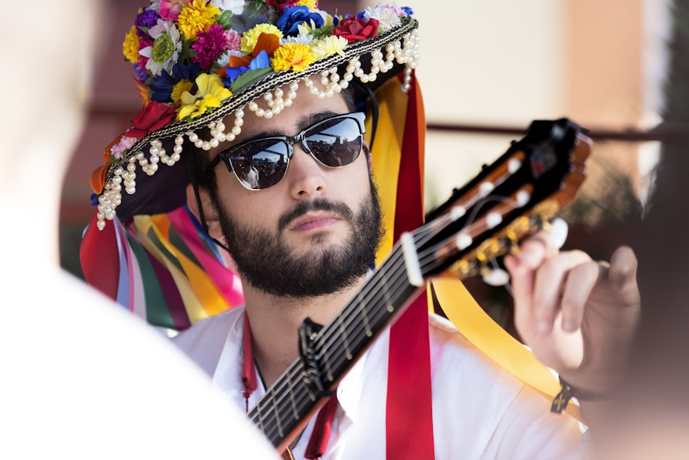 Homme portant un accordeur de guitare à col blanc