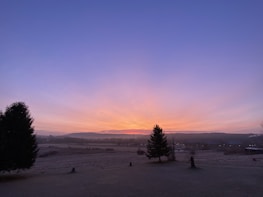 A peaceful landscape with a red sky just before dawn.