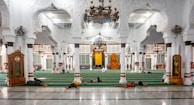 A team cleaning a large mosque interior with attention to detail.