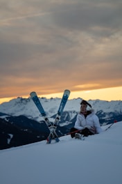 man sitting beside a snow ski blades