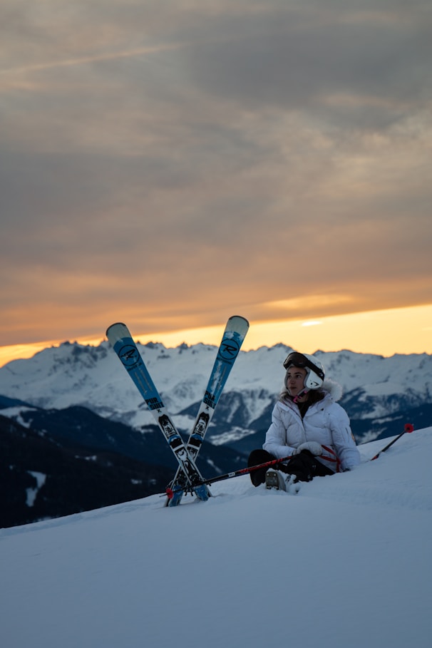 man sitting beside a snow ski blades