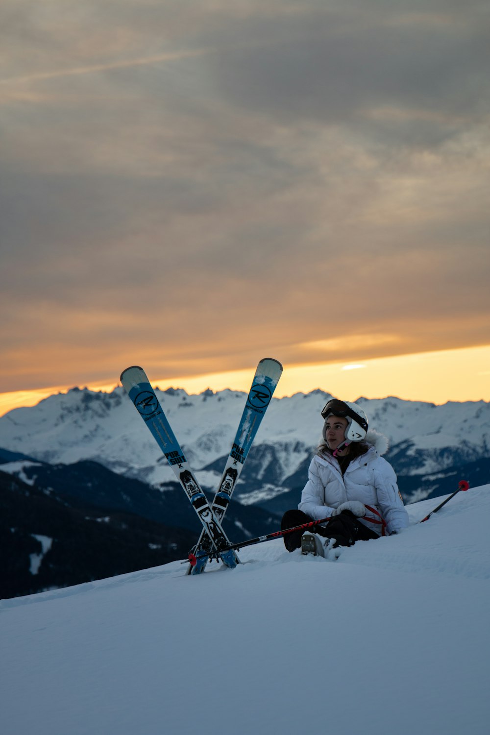 homme assis à côté d’une lame de ski de neige