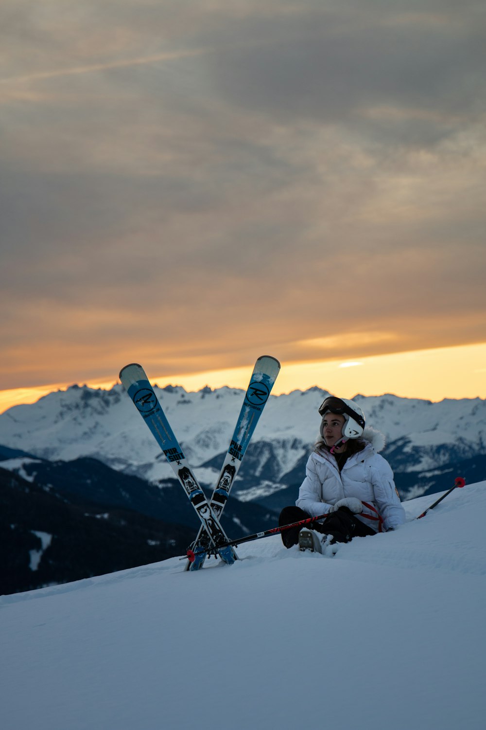 uomo seduto accanto a lame da sci da neve