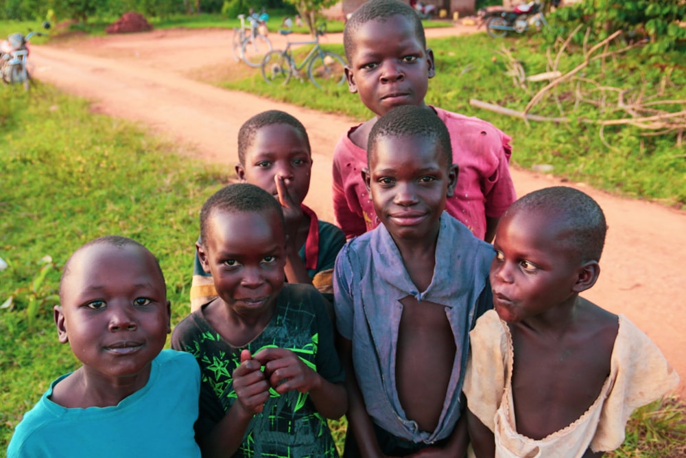 Sechs Kinder stehen in der Nähe einer holprigen Straße