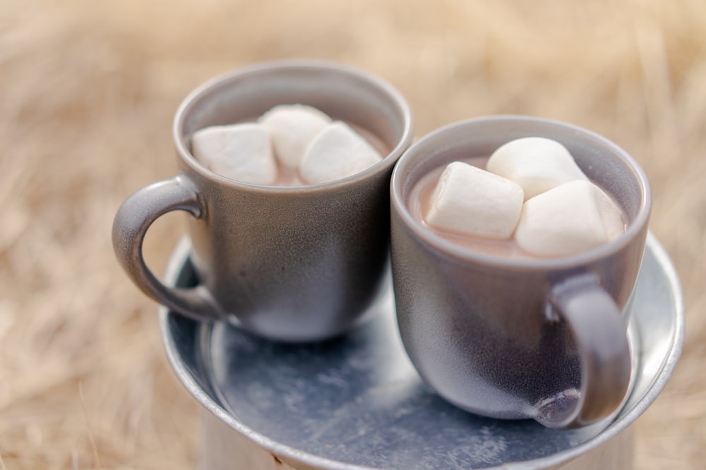 deux tasses de boissons et des guimauves