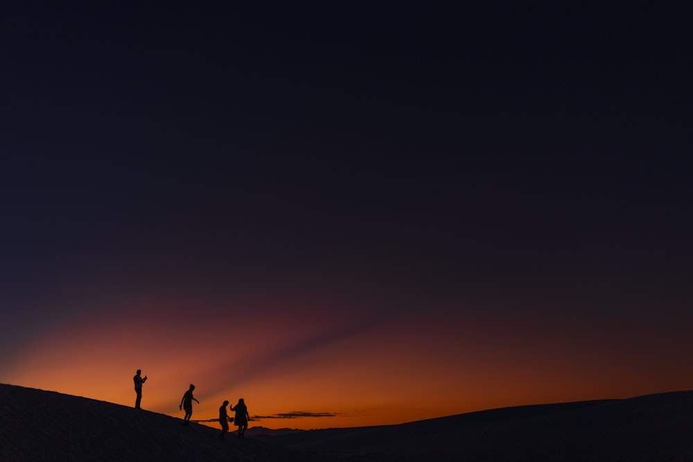 four people standing during golden hour