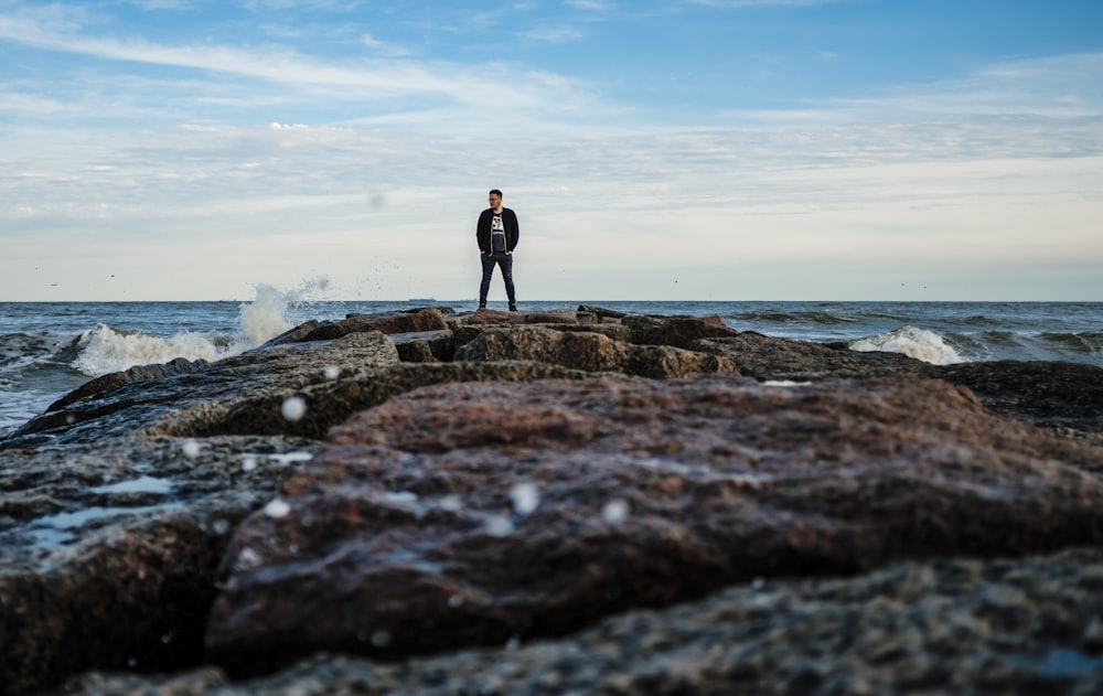 man standing on rocky shore