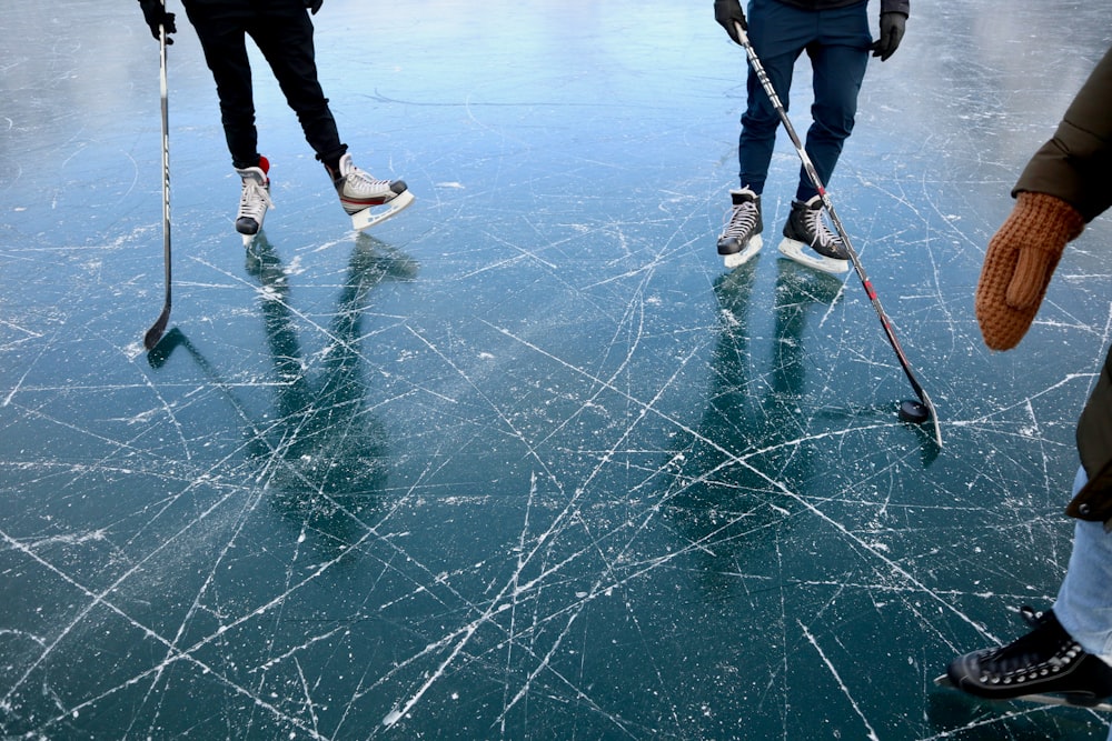 three persons playing ice hockey