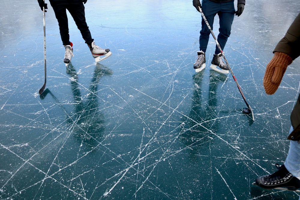 Drei Personen spielen Eishockey
