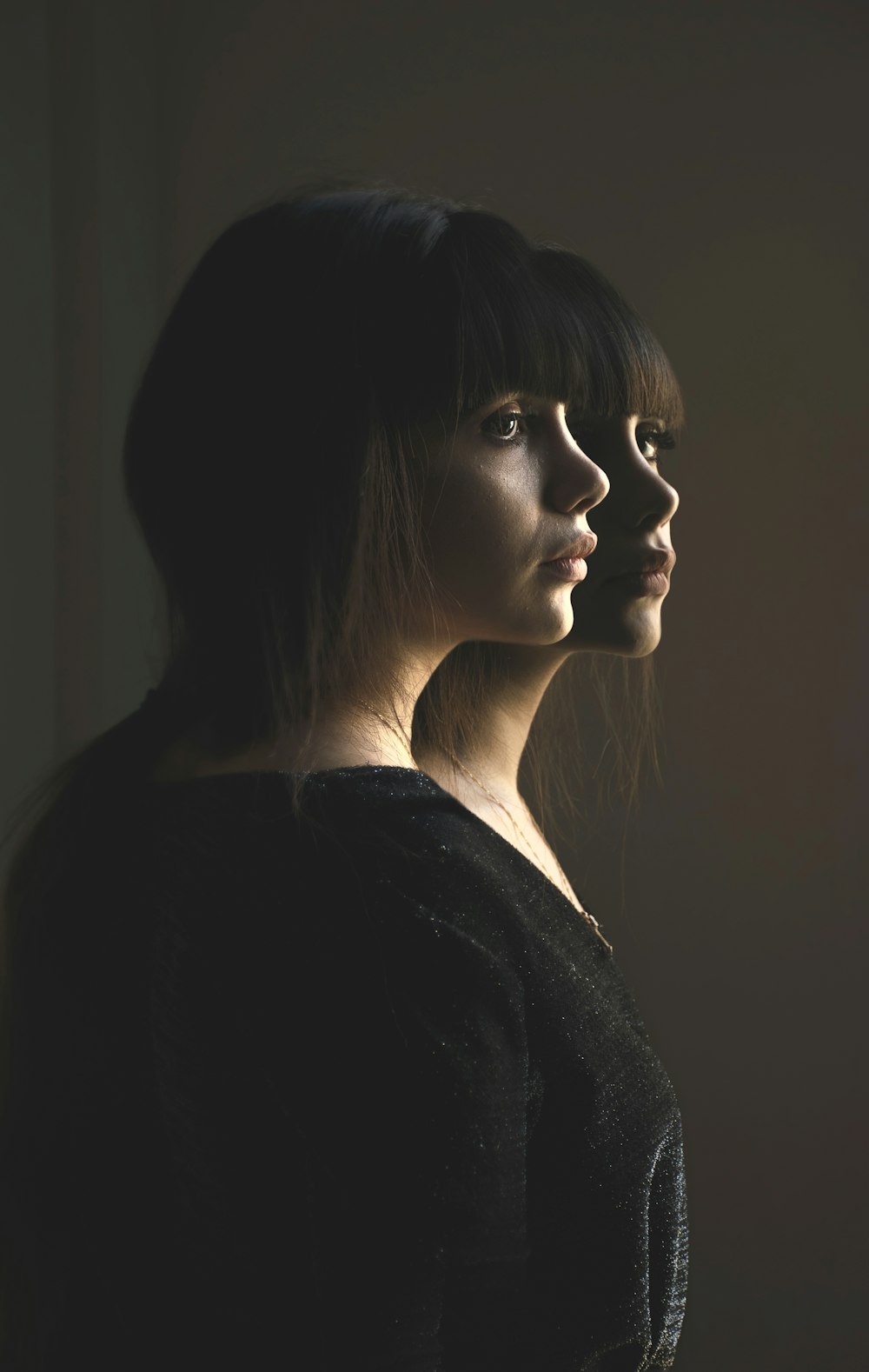 woman wearing black blouse standing near the glass