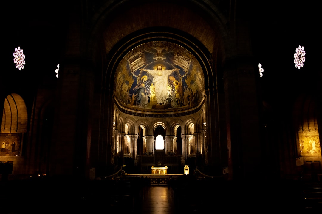 a dimly lit church with a painting on the wall,