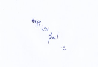 A handwritten message in blue ink stating 'Happy New Year!' with an accompanying smiley face at the bottom.