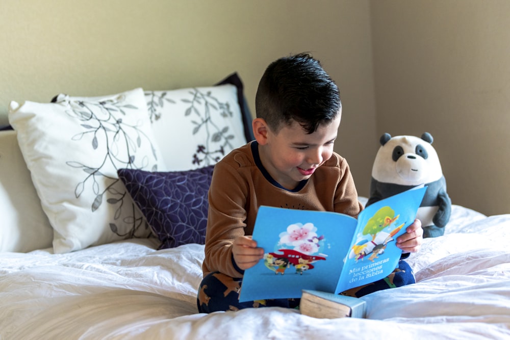 boy reading book on bed