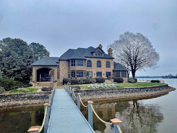 Elegant exterior of a waterfront home with large windows reflecting the lake