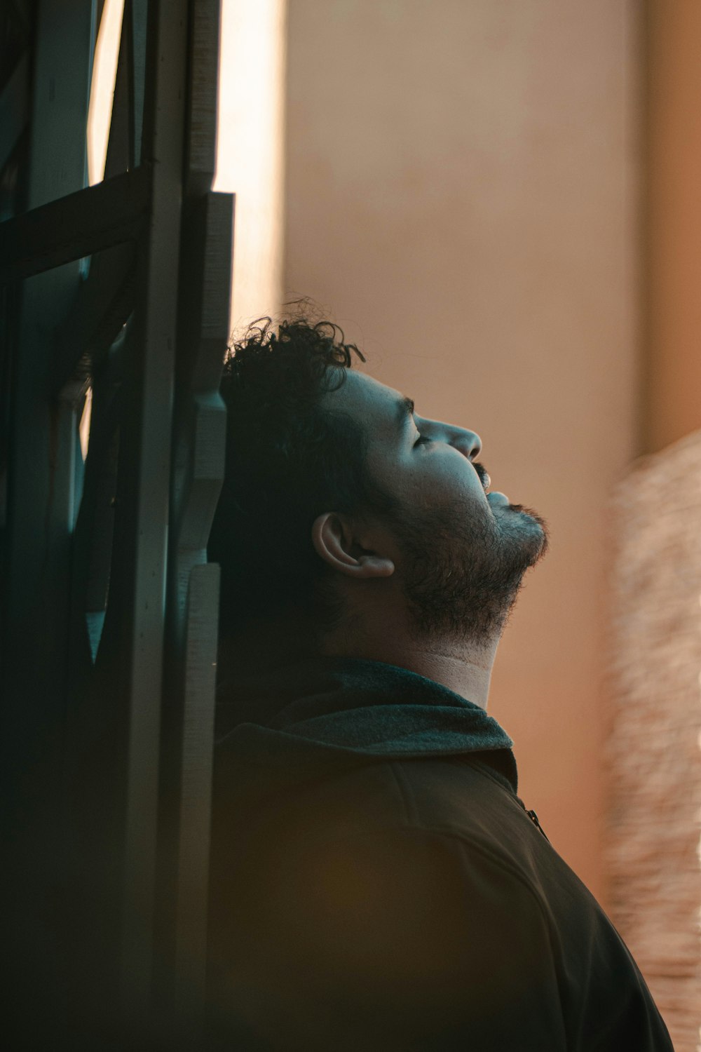 a man standing next to a window looking up