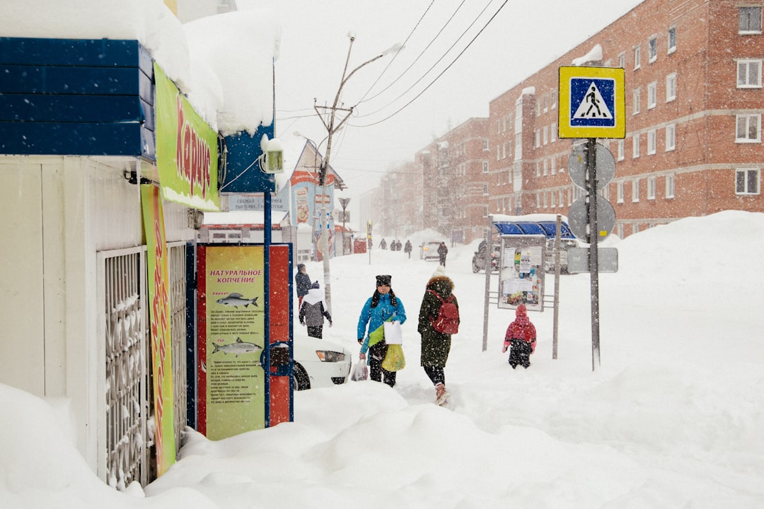 people walking along snow-covered street
