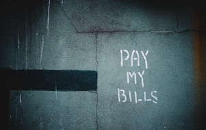 shallow focus photo of wall with pay my bills paint