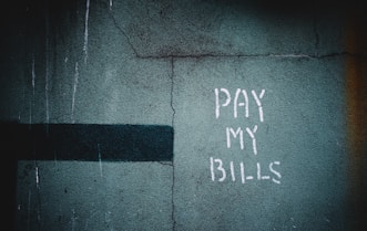 shallow focus photo of wall with pay my bills paint