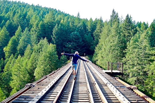 man walking on the train railings in Victoria Canada