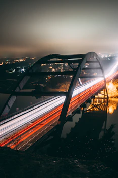 time-lapse photography of vehicles passing by a bridge during nighttime