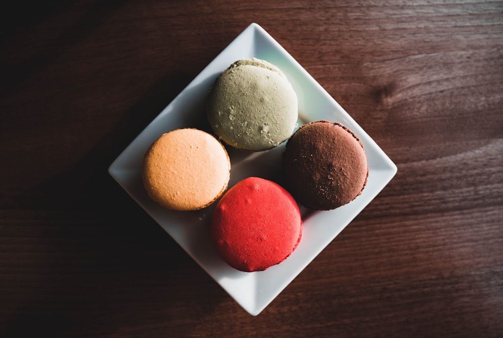 four assorted-colored French macarons