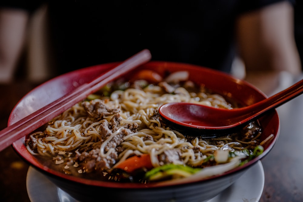 noodles with meat in round red bowl