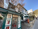 A bustling coffee shop storefront framed by colorful autumn leaves in a Denver neighborhood.
