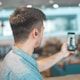 shallow focus photo of man in gray collared top taking selfie