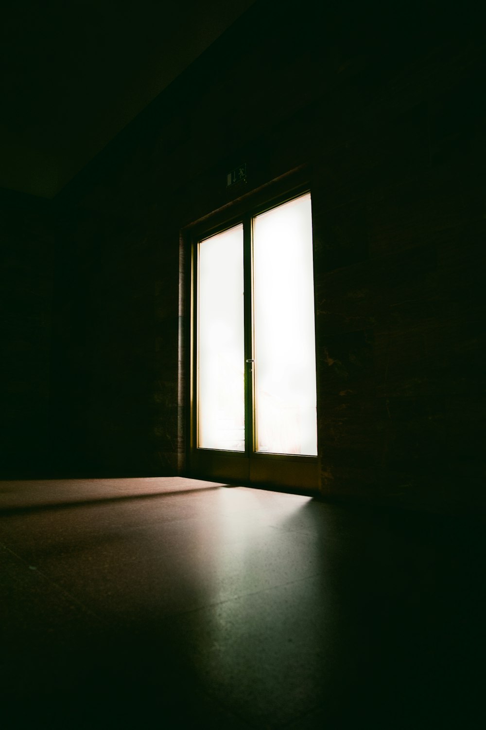 um quarto escuro com uma janela e um chão