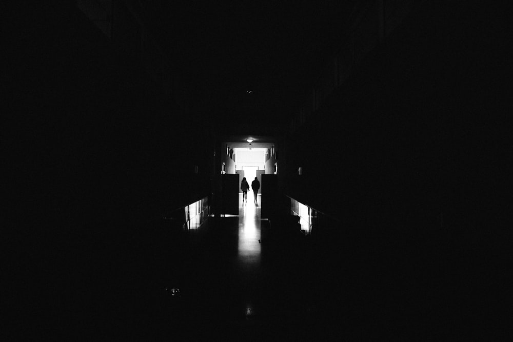 a person walking down a dark hallway at night