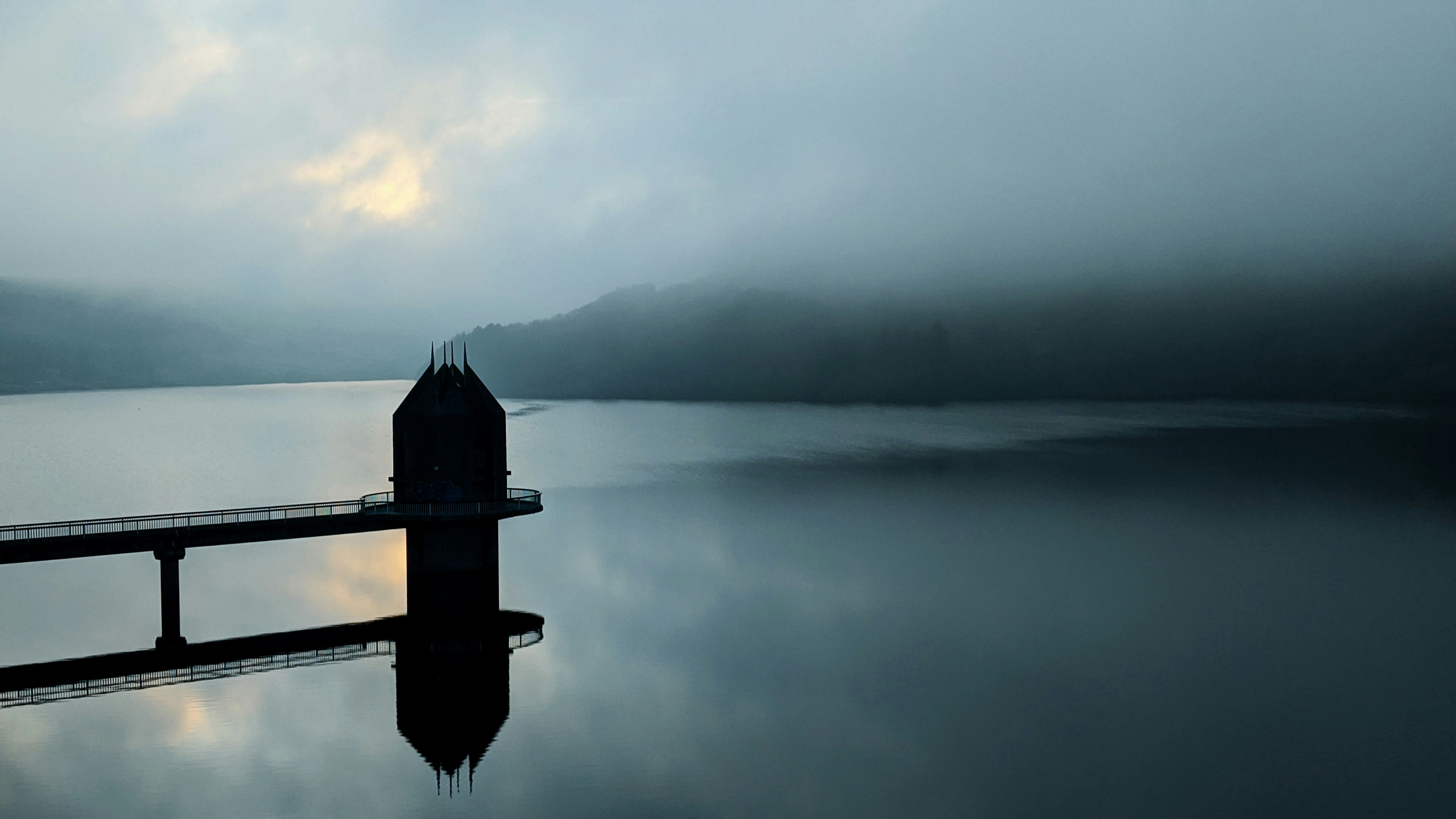 silhouette of dock on body of water