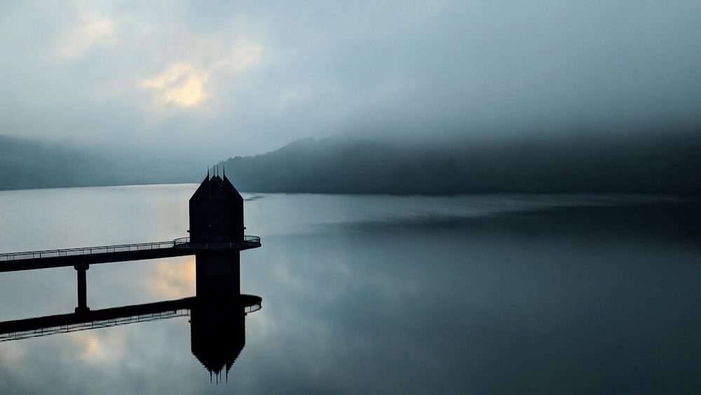 silhouette of dock on body of water