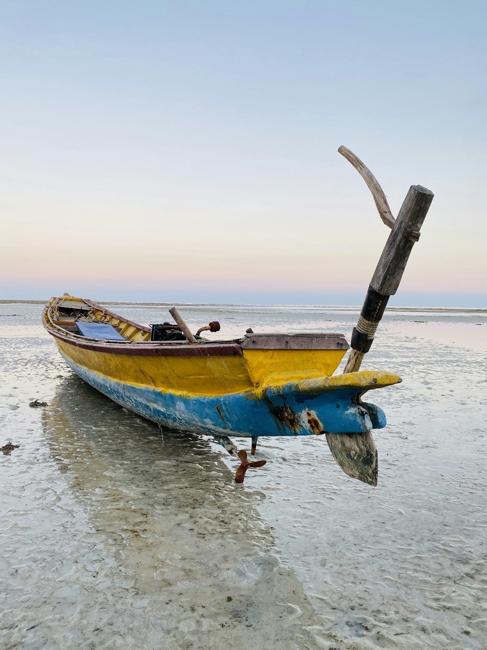 docked yellow boat on shore during day