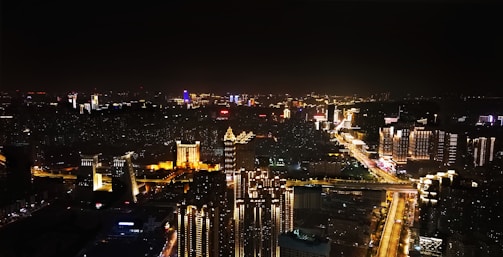 City skyline at night with bright lights and lively streets