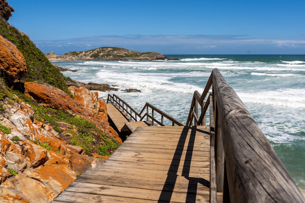 brown wooden pathway with stairs and railing on island during day