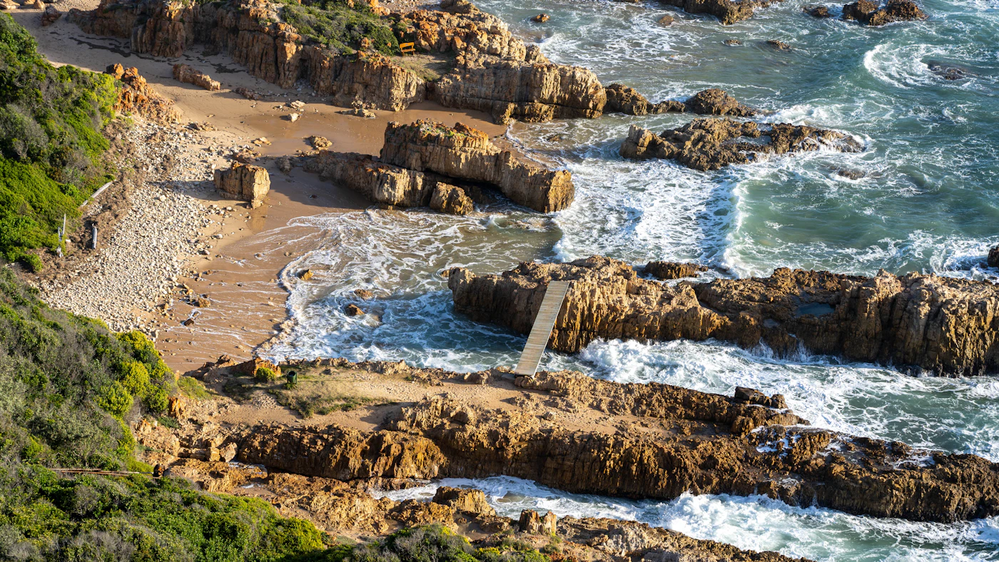 Waves washing over layered coastal rocks