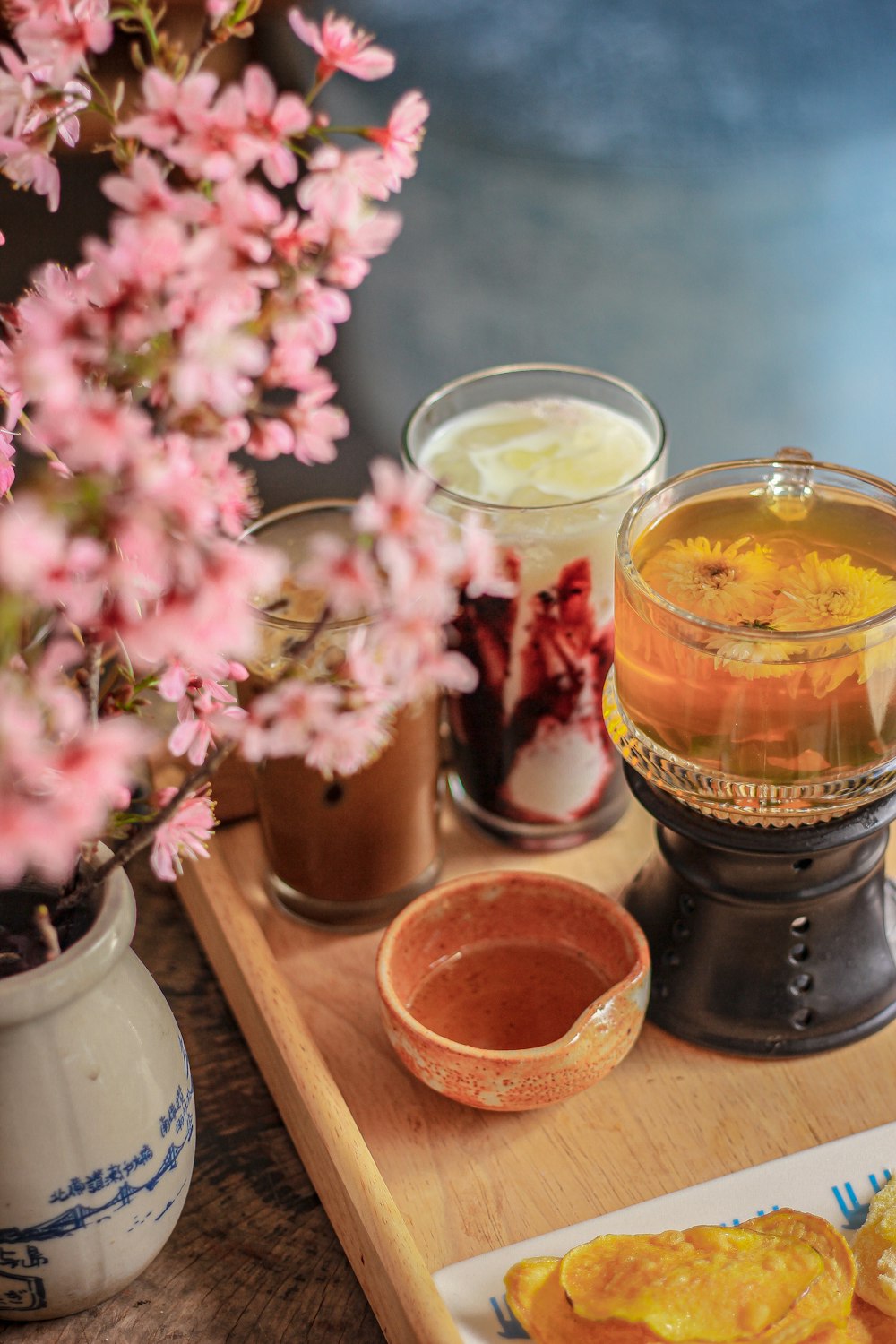 fiori rosa in vaso accanto alle bevande