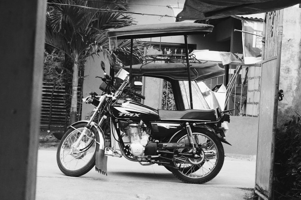 Motocicleta estacionada con cabina del lado del pasajero cerca de edificios