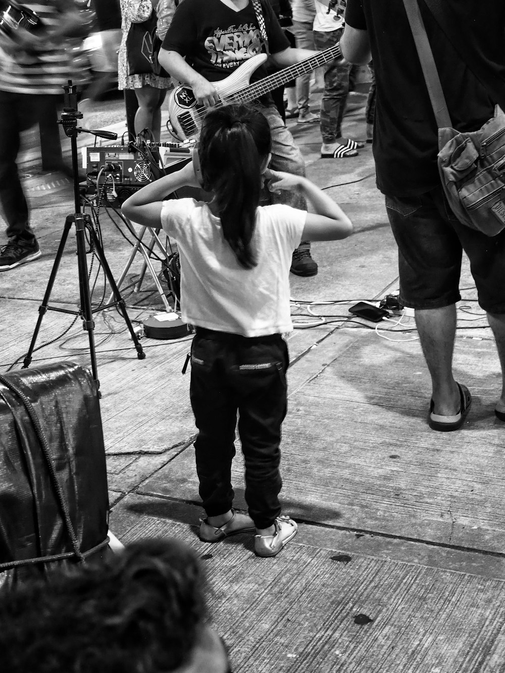 girl covering her ears near people