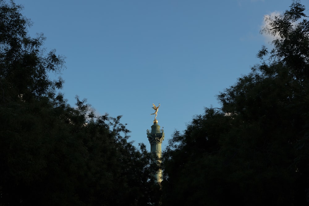 a view of a statue through the trees