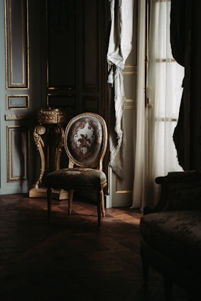 Silky robes draped elegantly over a vintage chair with deep burgundy accents