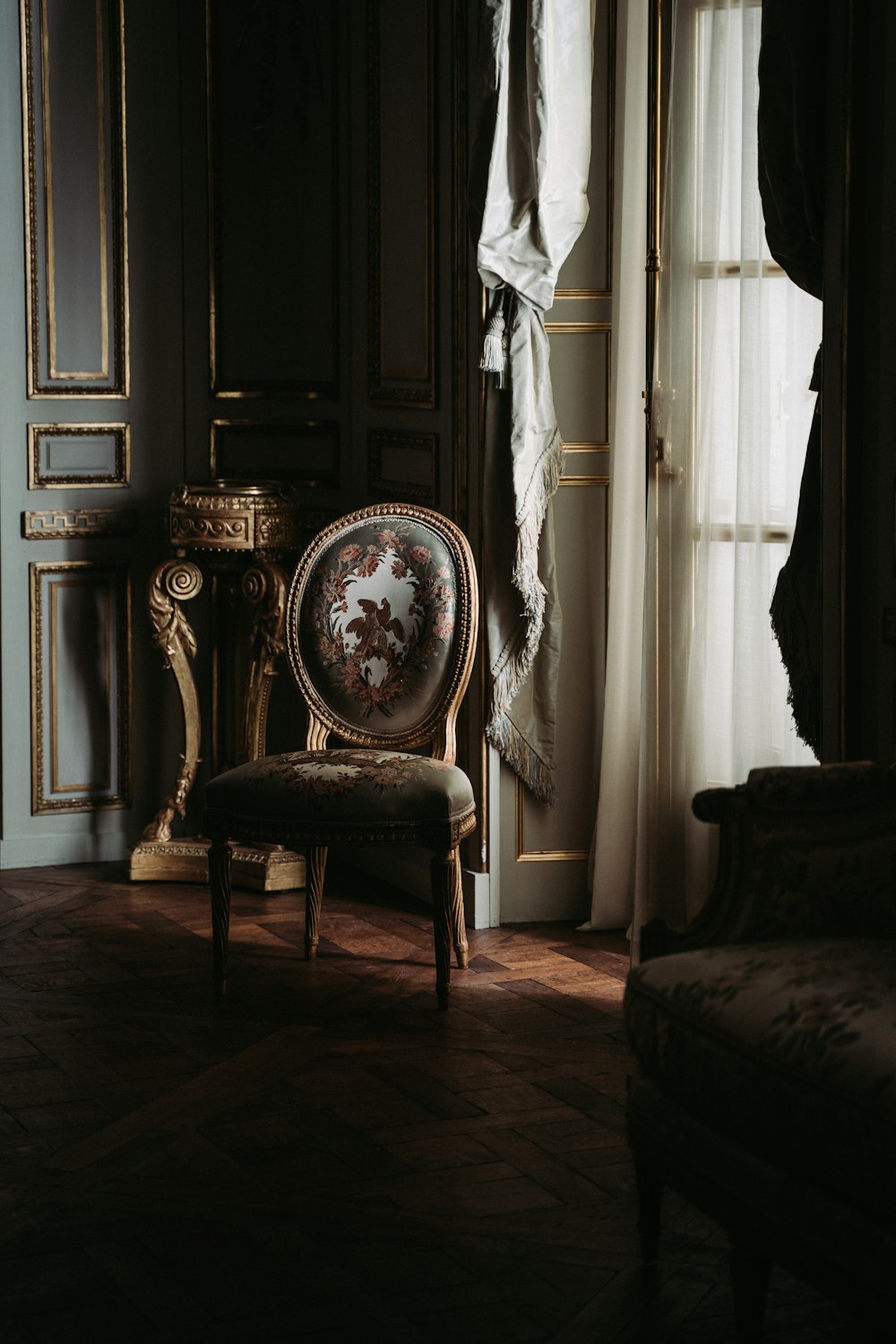 chaise florale marron à côté de la fenêtre