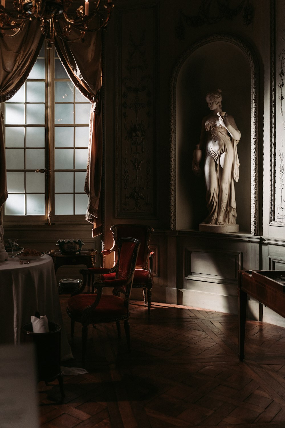 chair beside table beside statue