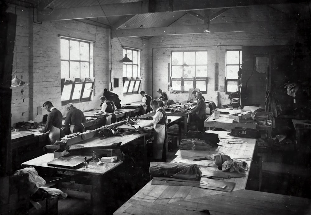 a black and white photo of people working in a factory