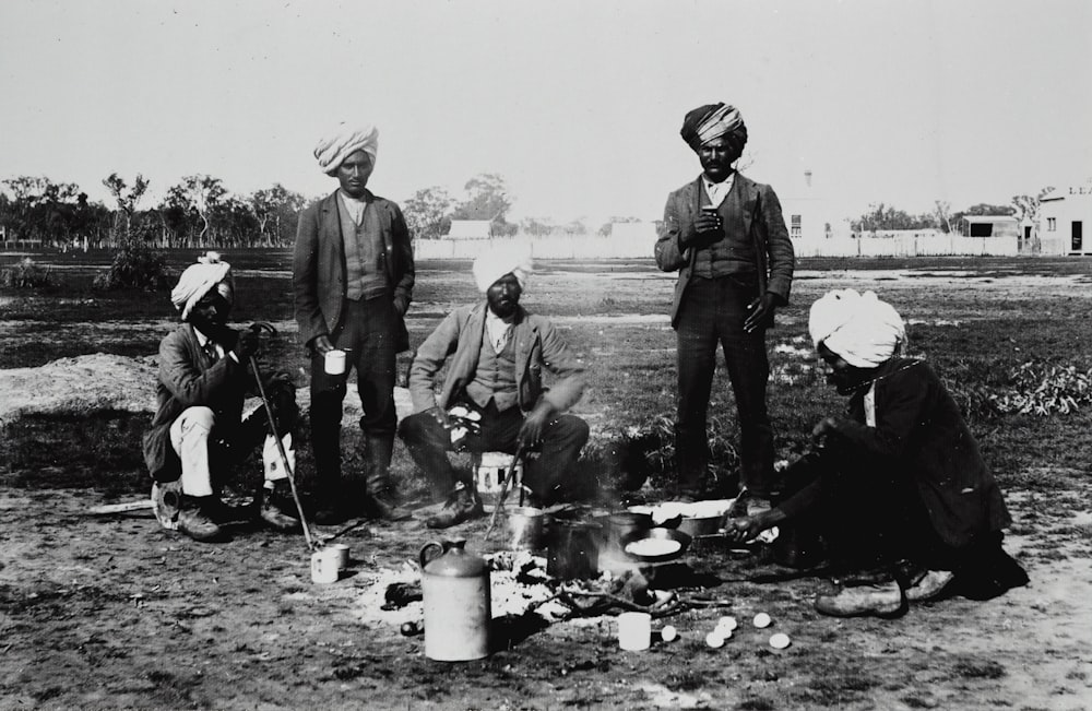 group of men sitting beside campfire