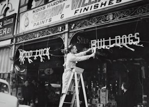 Marcus Bullard standing proudly in front of Parker Sales and Service with the shop sign overhead.