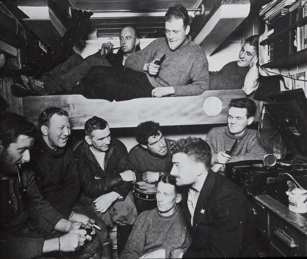 a group of men sitting around a bunk bed
