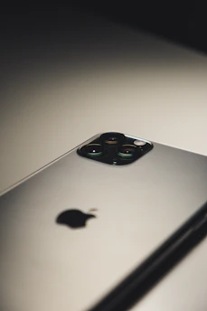 Close-up photo of the latest model smartphone on a sleek surface with soft lighting highlighting its design