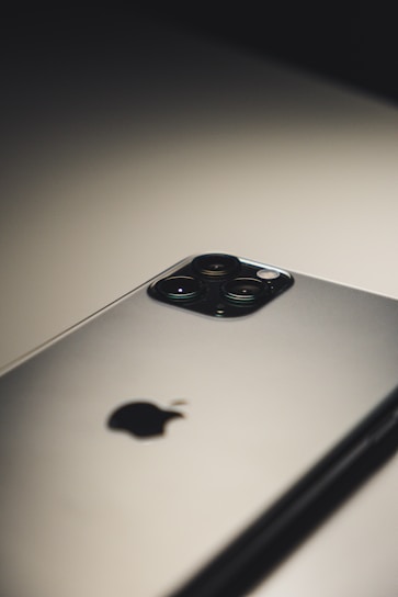 A close-up shot of a sleek refurbished smartphone resting on a wooden table with soft natural light highlighting its polished surface.