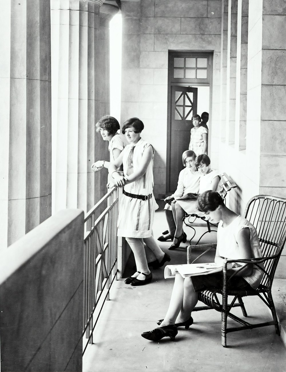 group of woman sitting and standing beside railing
